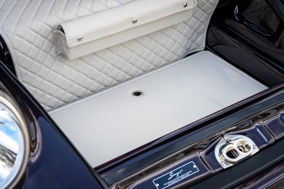 Aubergine metallic Singer Porsche 911 trunk lined with diamond-stitched cream leather.