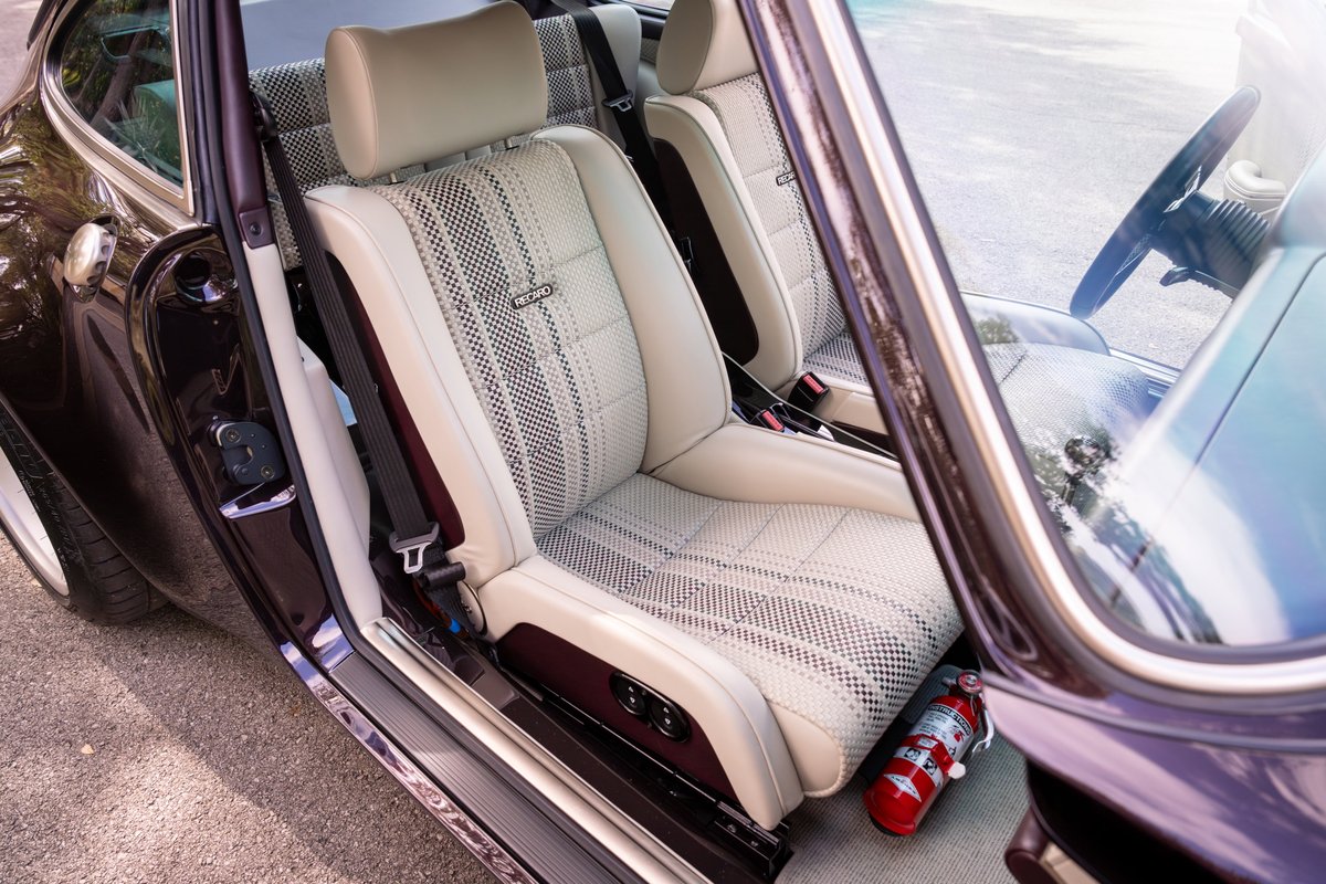 Singer 911 interior: Tan upholstery with geometric pattern trim, red fire extinguisher.
