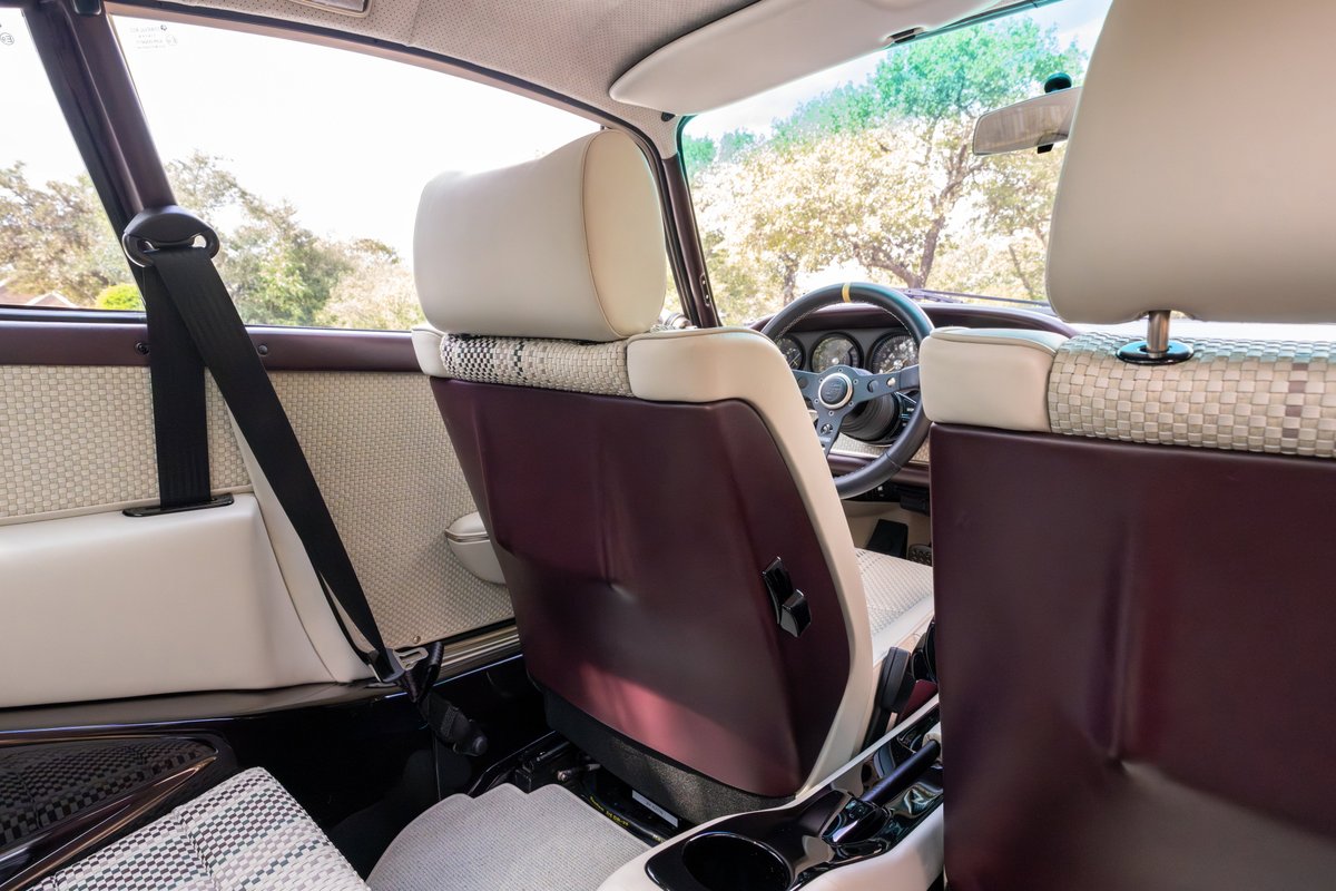 Singer 911 interior with aubergine trim, classic gauges, and patterned fabric inserts.
