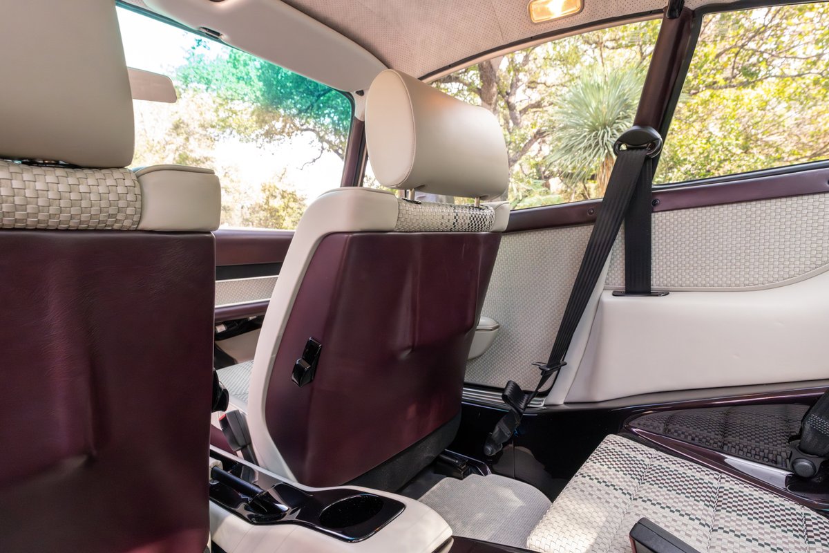 Interior of a 1990 Singer Porsche 911 in Aubergine Metallic with woven seat inserts and dark trim.