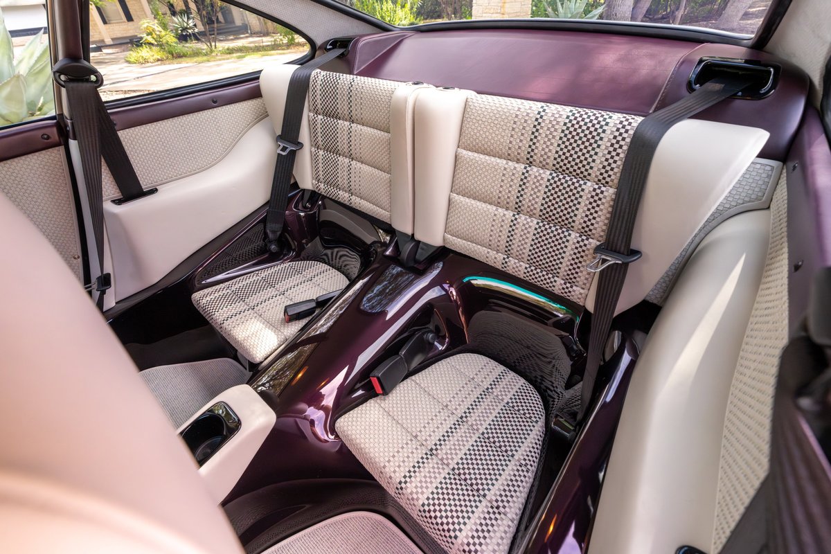 Aubergine metallic Singer 911 rear interior with plaid seat inserts and dark trim.