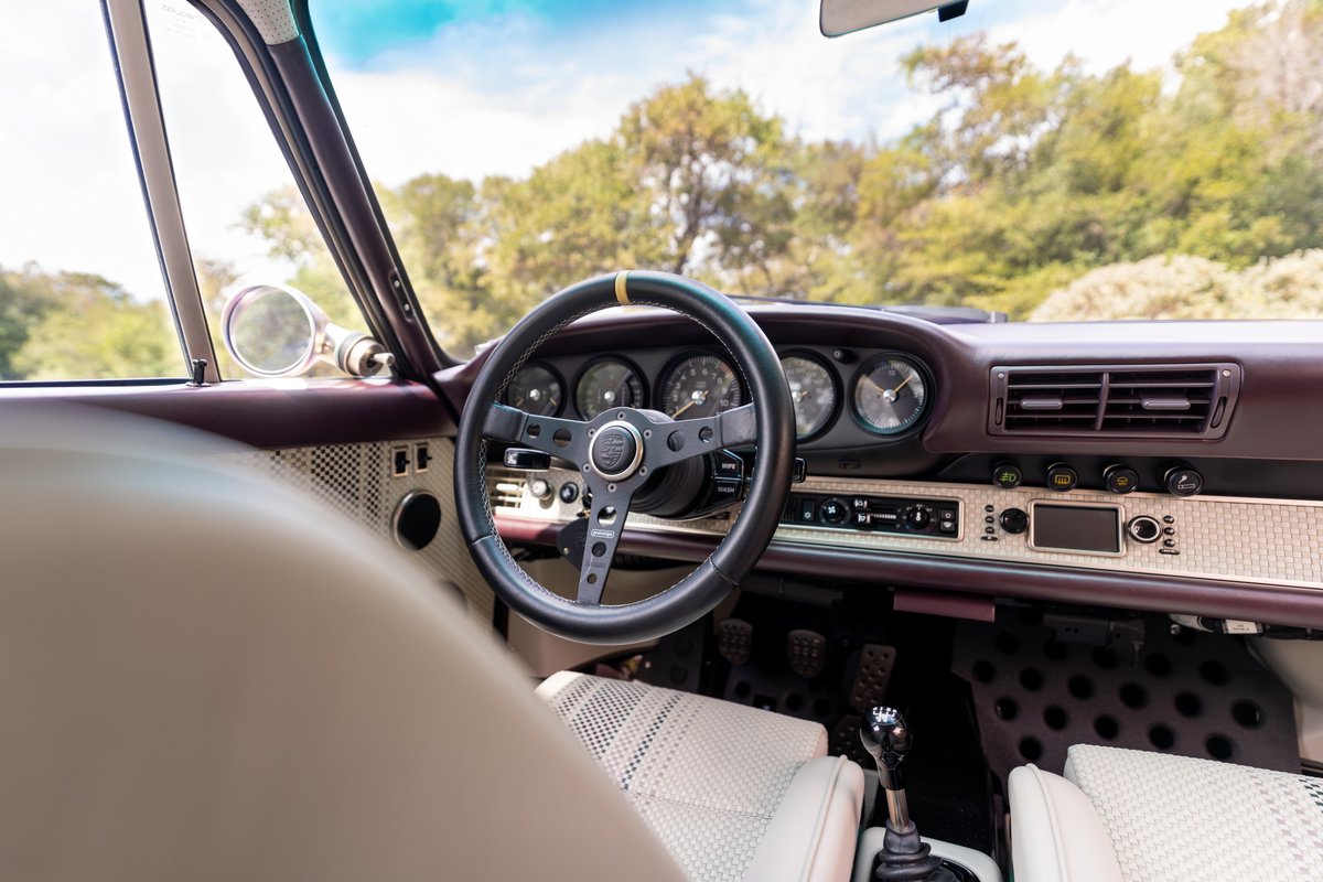 1990 Singer Porsche 911 interior in aubergine metallic. Features vintage steering wheel & quilted seats.