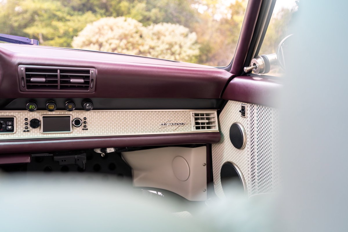 Aubergine metallic 1990 Singer 911 interior with retro trim and speaker accents.