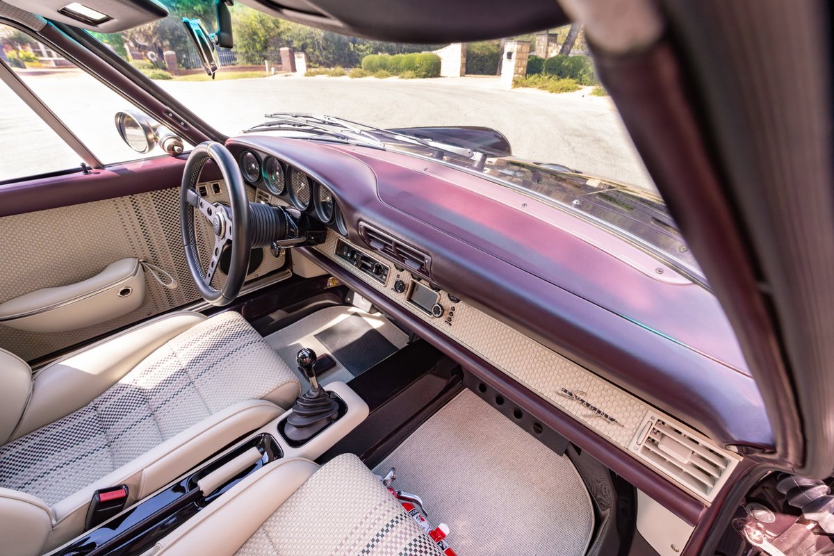 Singer 911 interior: aubergine metallic dash, leather seats, sports steering wheel, gated shifter.