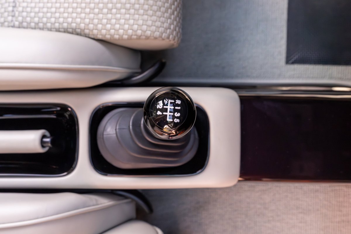 Close-up of a 1990 Singer 911's aubergine metallic manual gear shifter and console.