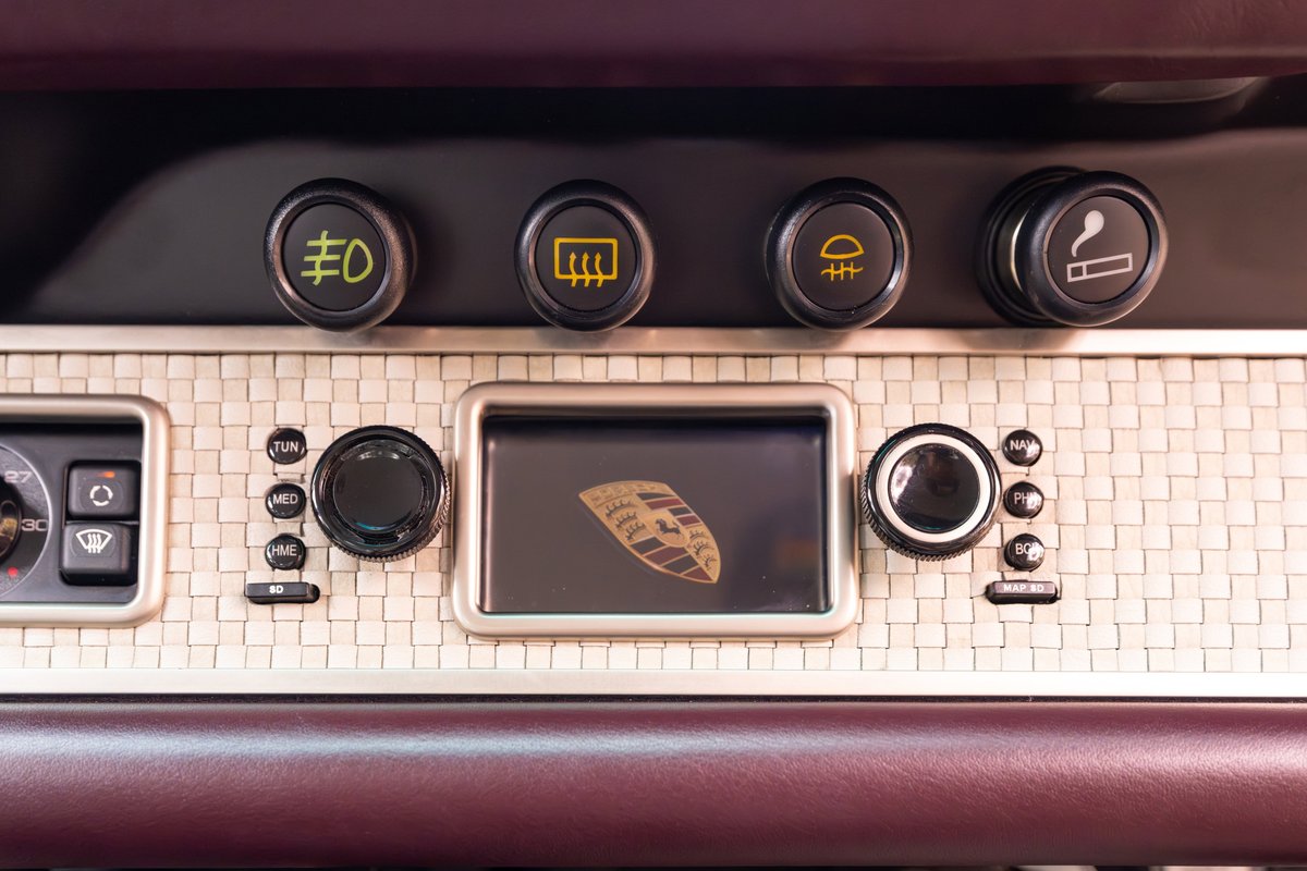 Close-up of the 1990 Singer Porsche 911 aubergine metallic dashboard trim with center screen.