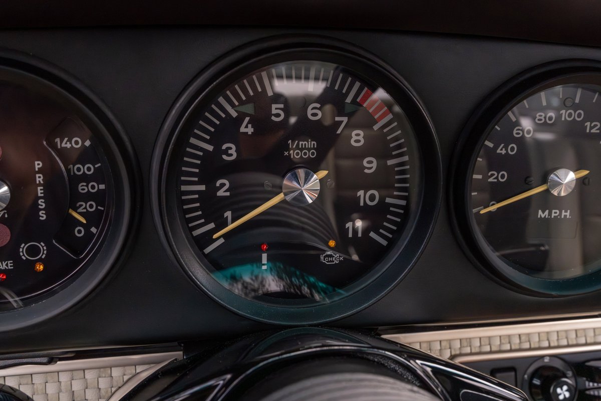 Classic Singer Porsche 911 dashboard gauges: tachometer, oil pressure, and MPH.