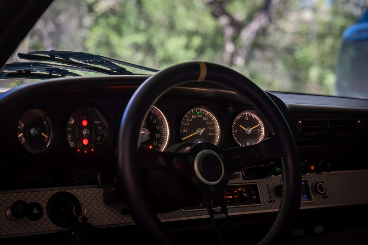 Singer Porsche 911 dashboard with yellow stripe on steering wheel.