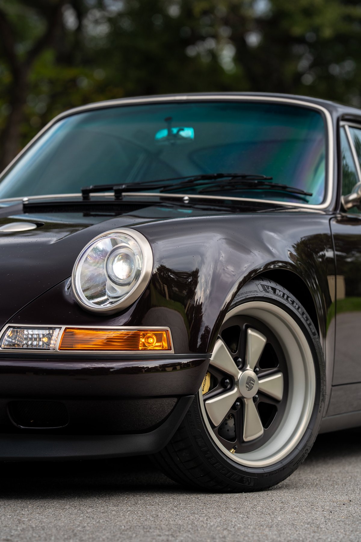 Aubergine Metallic 1990 Singer Porsche 911 front fender with classic Fuchs-style rims.