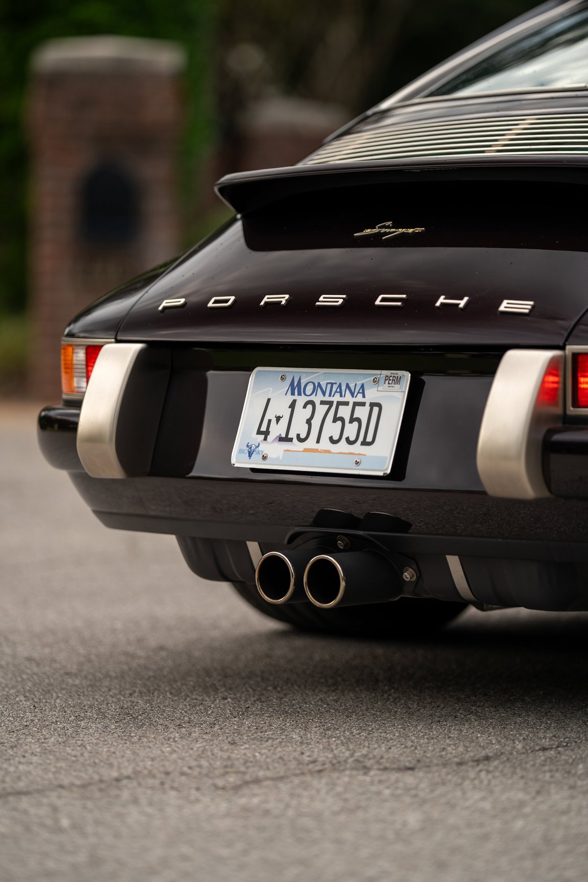 Aubergine metallic 1990 Singer Porsche 911 rear with gold script badging & dual exhaust.