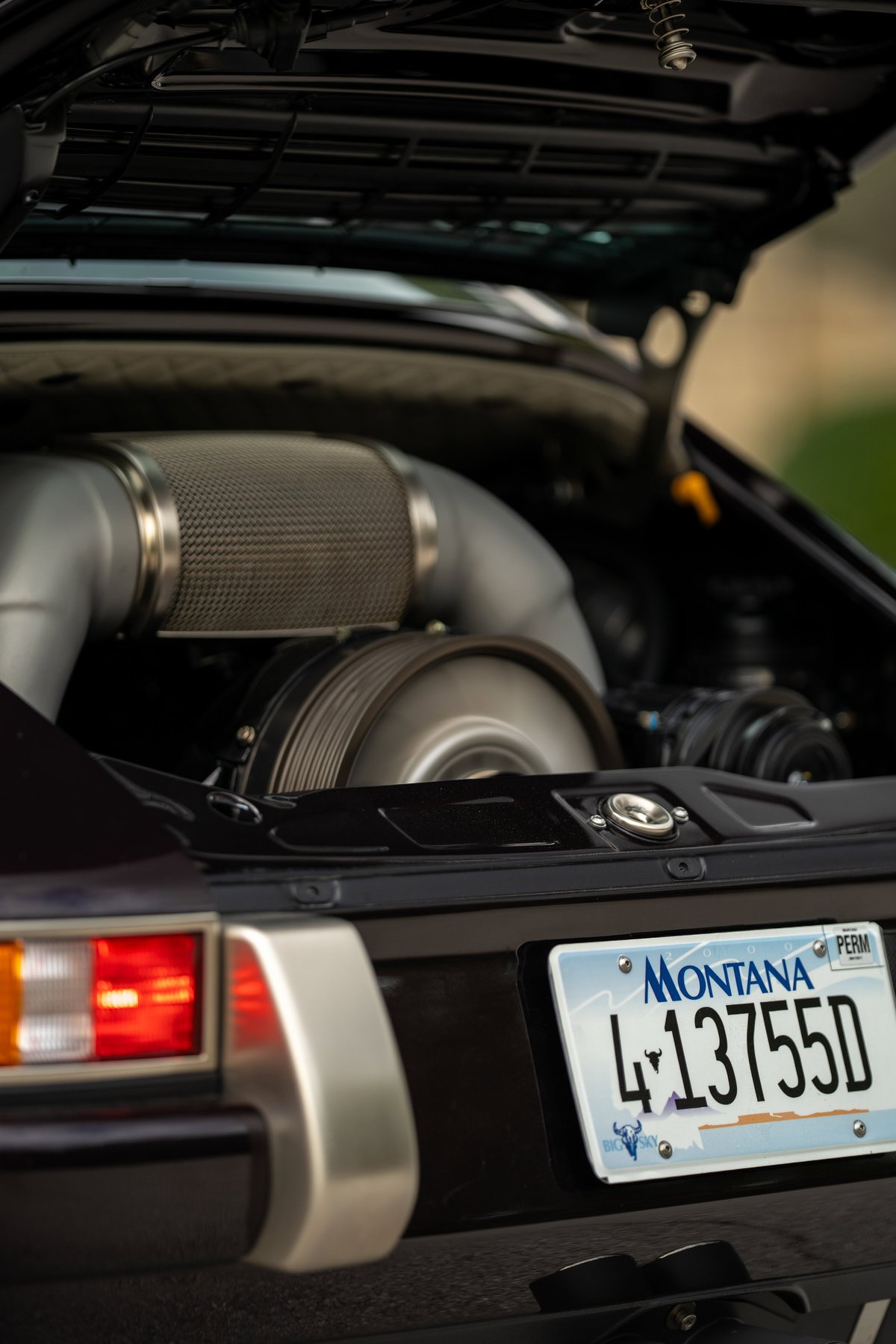 1990 Singer 911 in Aubergine Metallic showing turbocharger and polished metal trim.