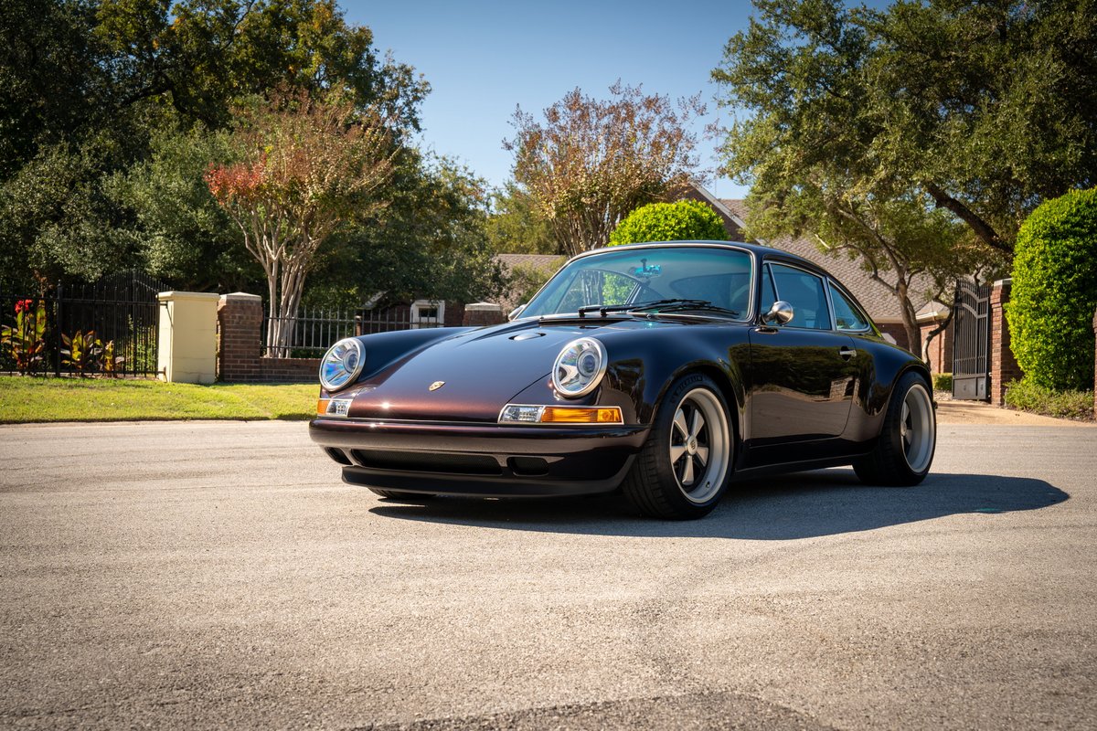 A custom Singer 911 in Aubergine Metallic, featuring Fuchs-style rims and wide-body trim.