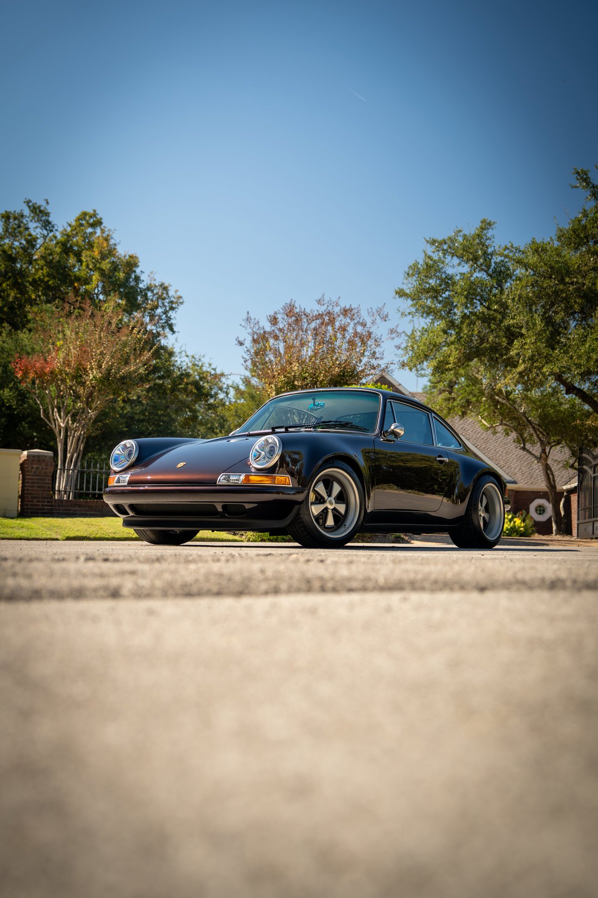 Aubergine metallic 1990 Singer 911 Porsche with silver alloy rims and chrome trim.