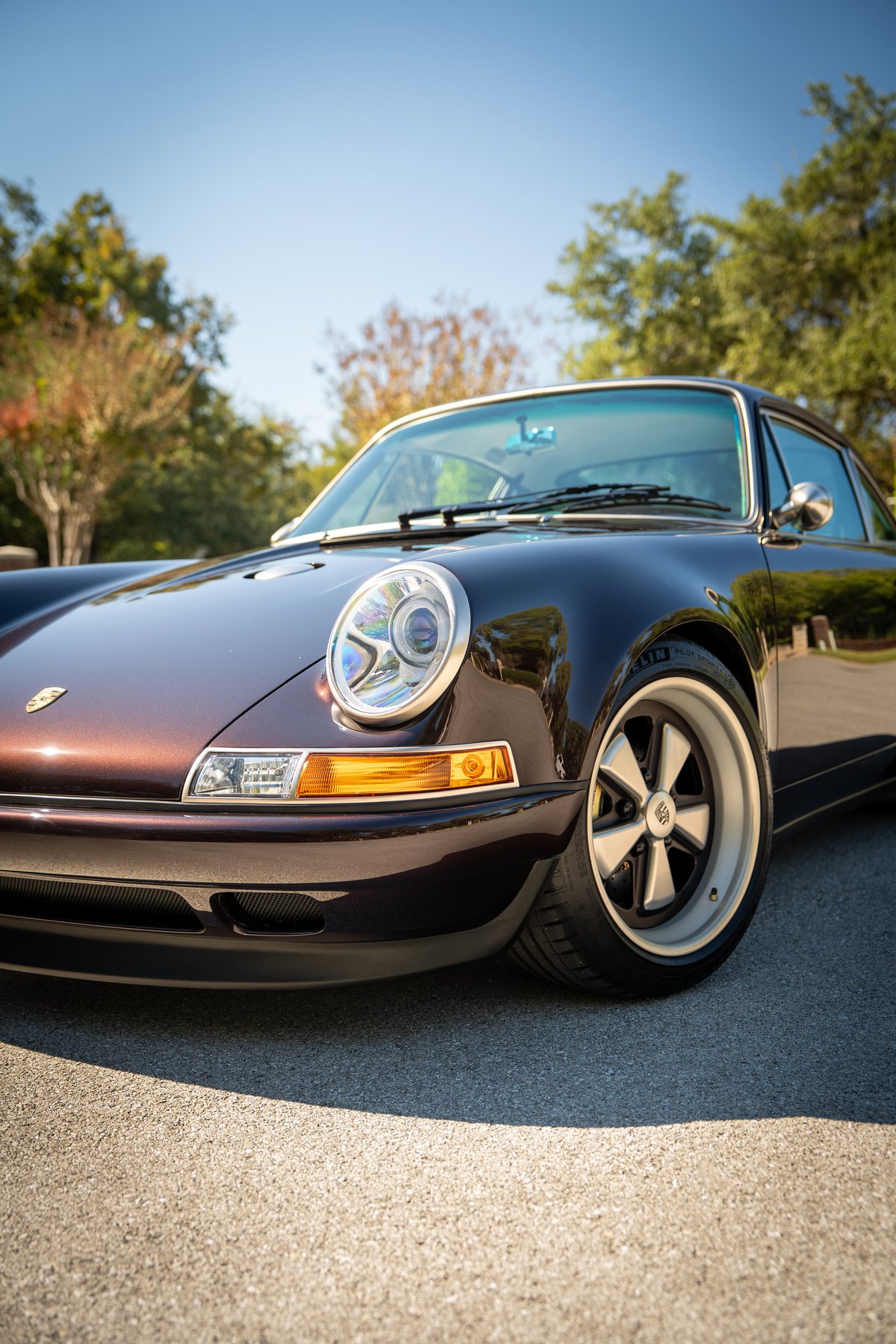 Aubergine Metallic 1990 Singer 911 front quarter, showing Fuchs wheels and chrome trim.