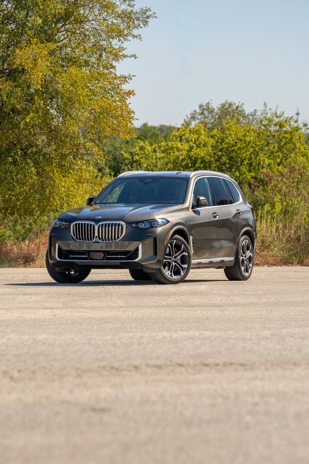 2026 BMW X5 in Manhattan Green, featuring multi-spoke alloy rims and chrome trim.