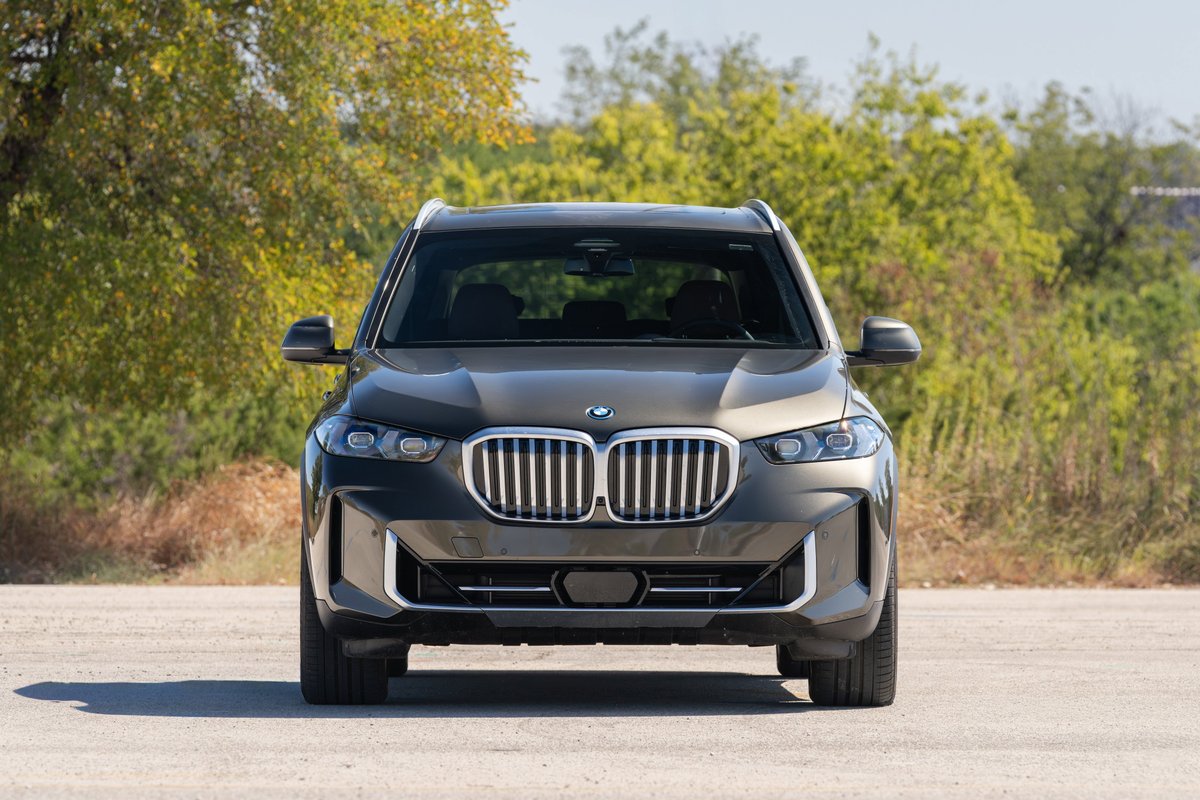 Front view of a Manhattan Green 2026 BMW X5 SUV with chrome kidney grille and bumper trim.