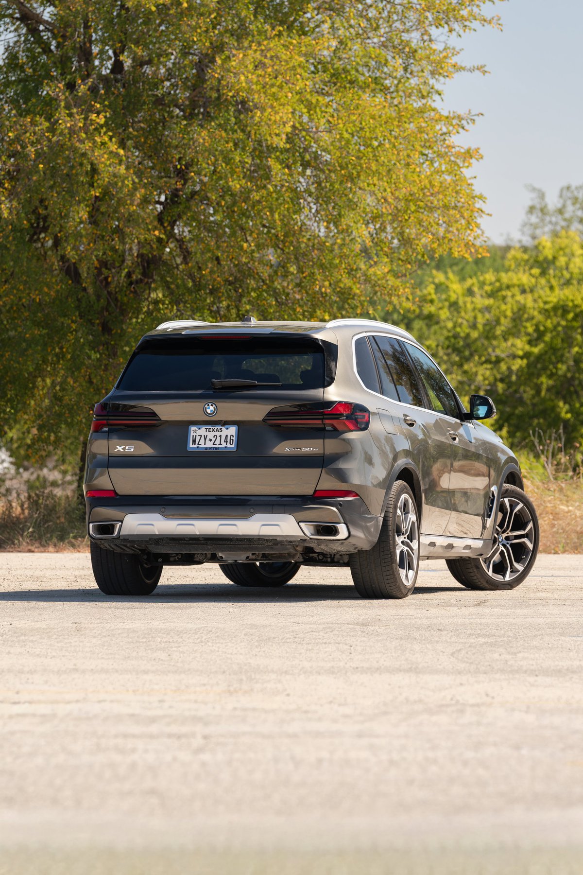 2026 BMW X5 in Manhattan Green with large alloy rims and silver skid plate.