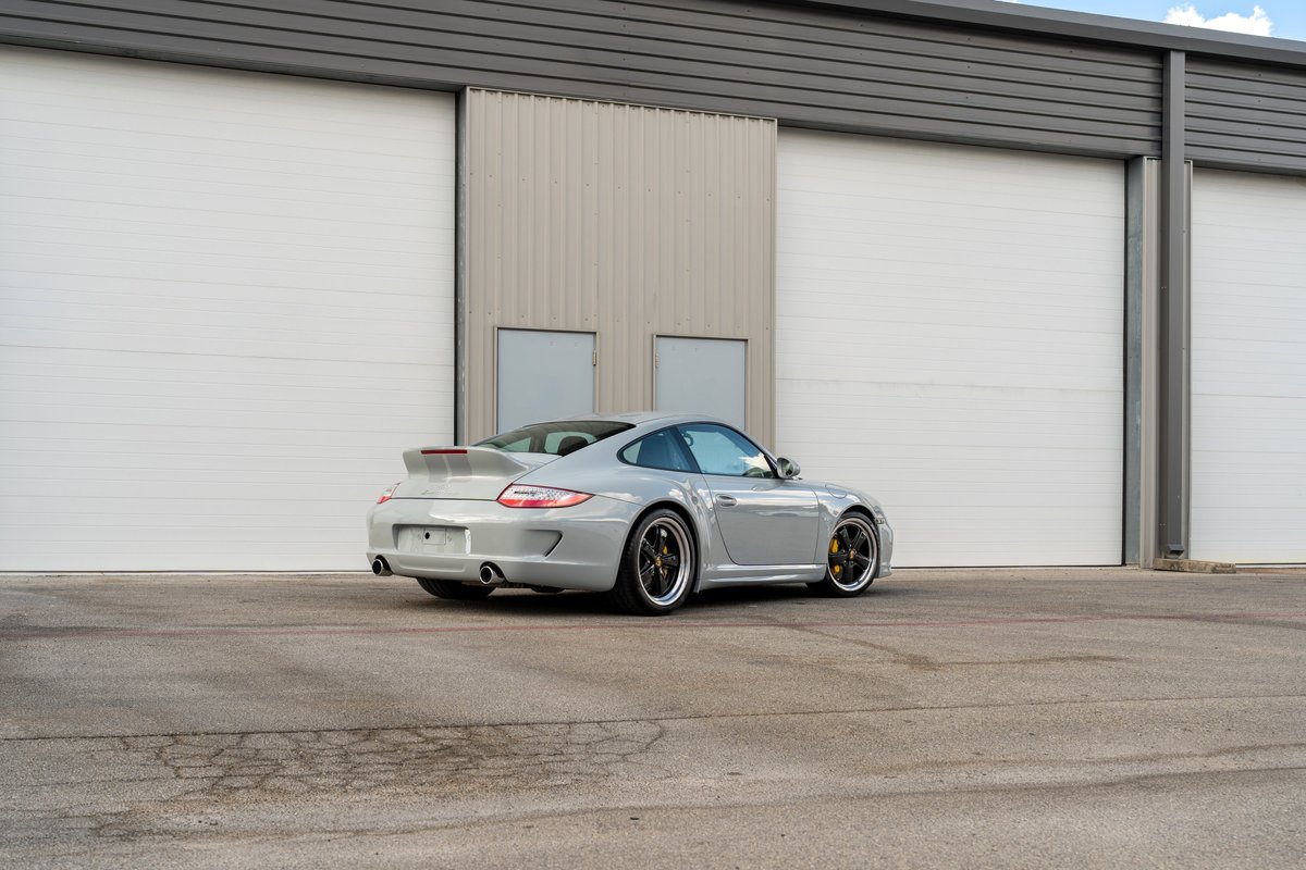 2010 Porsche 911 Sport Classic in grey, featuring multi-spoke rims and a large rear spoiler.