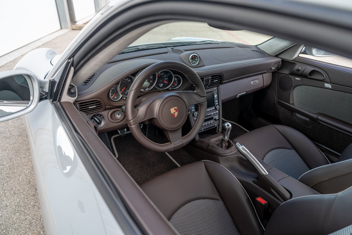 Interior view of a light-colored 2010 Porsche 911 Sport Classic with leather and Alcantara trim.