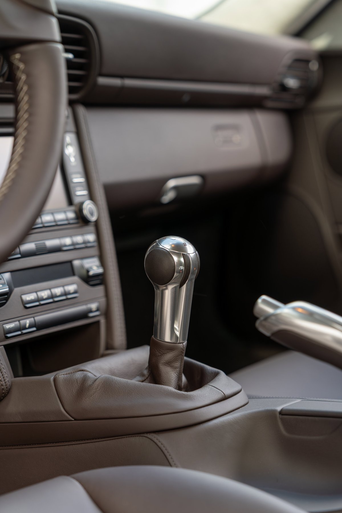 Close-up of the brushed aluminum and leather manual gear shifter in a 2010 Porsche 911 Sport Classic.