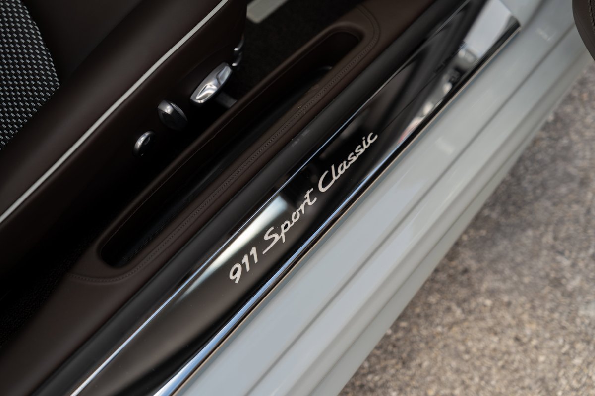 Close-up of the "911 Sport Classic" script on the illuminated door sill of a 2025 Porsche 911 Sport Classic.