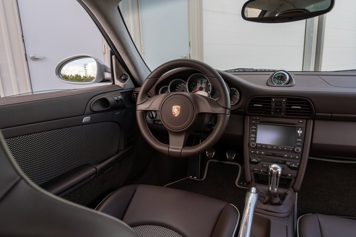 2010 Porsche 911 Sport Classic interior showing leather seats, dashboard, and infotainment system.