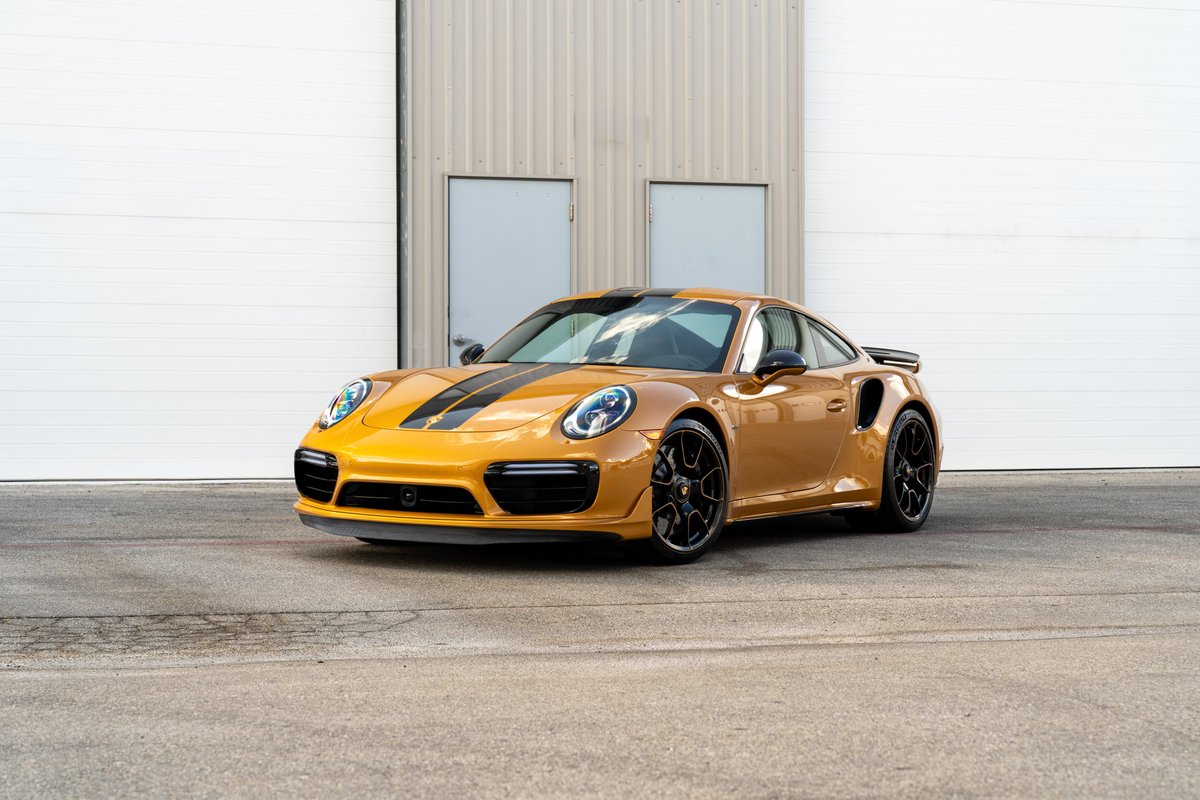2018 Porsche 911 Turbo S Exclusive Series in Golden Orange Metallic with black stripe livery and black rims.