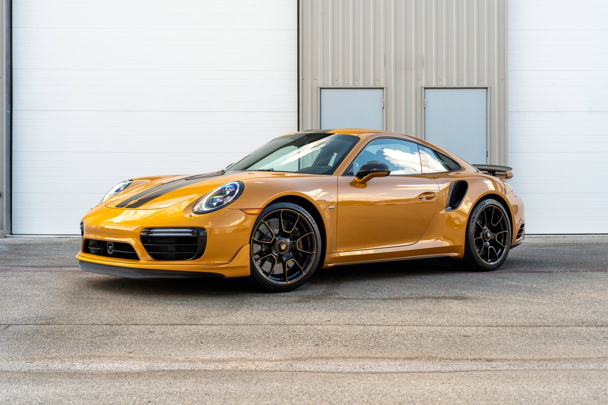 2018 Porsche 911 Turbo S Exclusive Series in gold with black racing stripes, black rims, and spoiler.