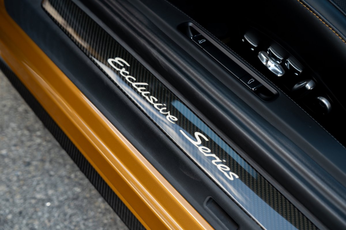 2018 Porsche 911 Turbo S Exclusive Series door sill trim with carbon fiber accent and seat controls.