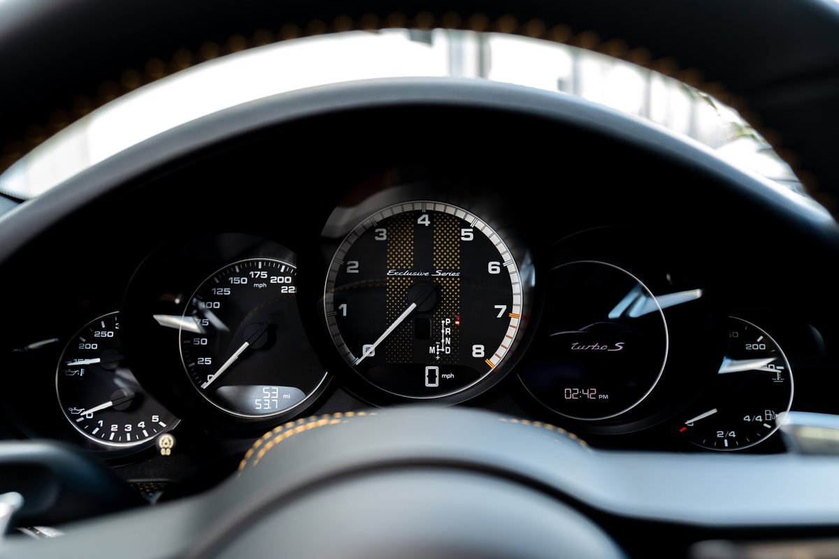 Close-up of the dashboard of a 2018 Porsche 911 Turbo S Exclusive Series, showing the gauges and steering wheel.