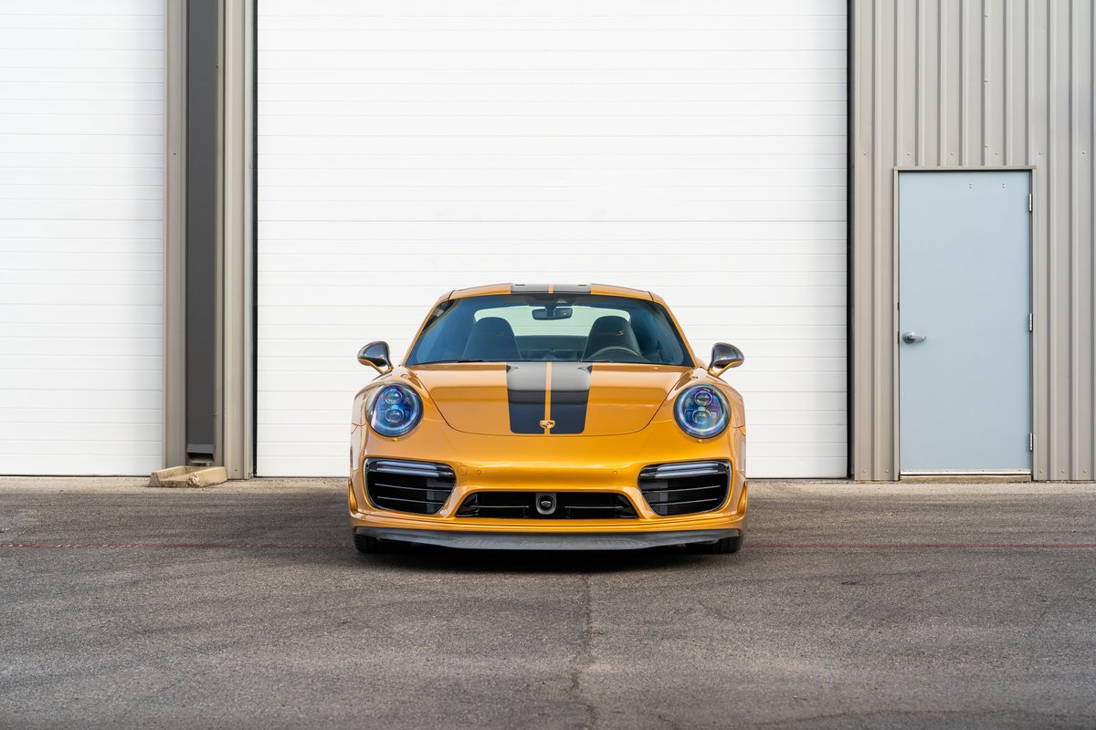 2018 Porsche 911 Turbo S Exclusive Series in gold with black stripe livery.
