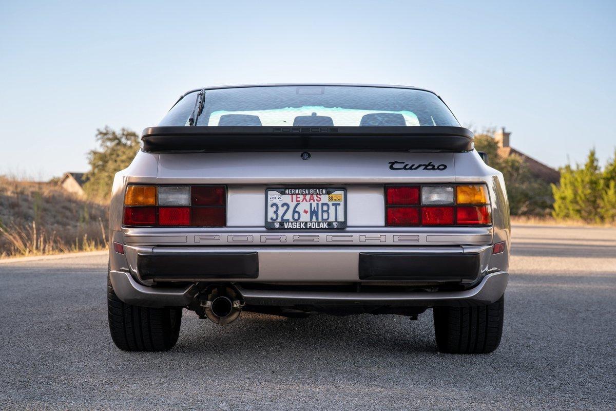 Rear view of a silver 1987 Porsche 944 Turbo S with a black spoiler and "Turbo" badging.