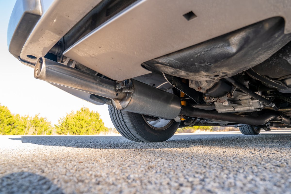 Rear view of a silver 1987 Porsche 944 Turbo S, showing the exhaust system and underside.