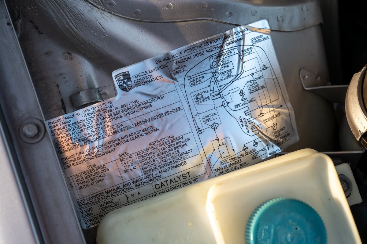 1987 Porsche 944 Turbo S emission control sticker in engine bay. Silver exterior.