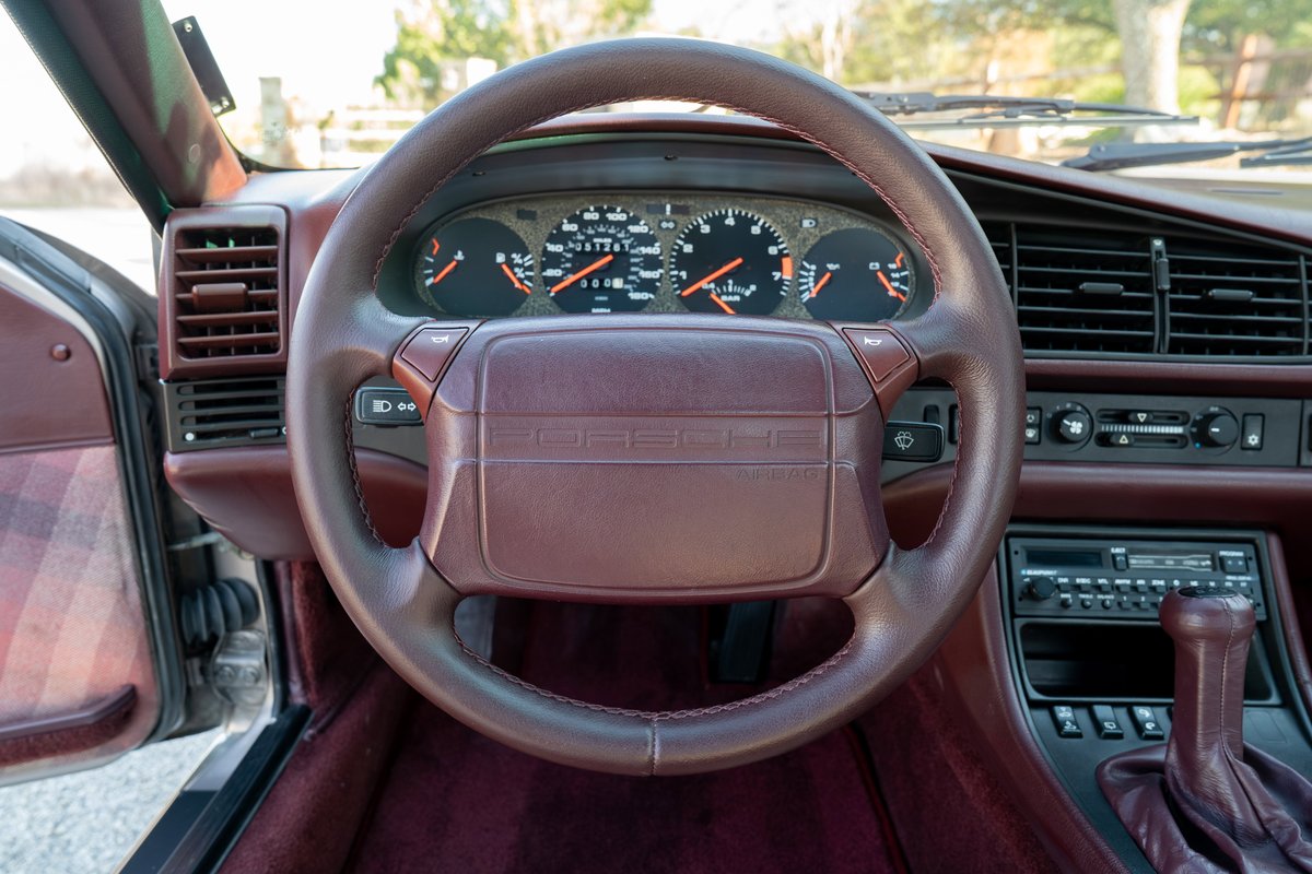 1987 Porsche 944 Turbo S interior: maroon leather steering wheel, dashboard and trim.