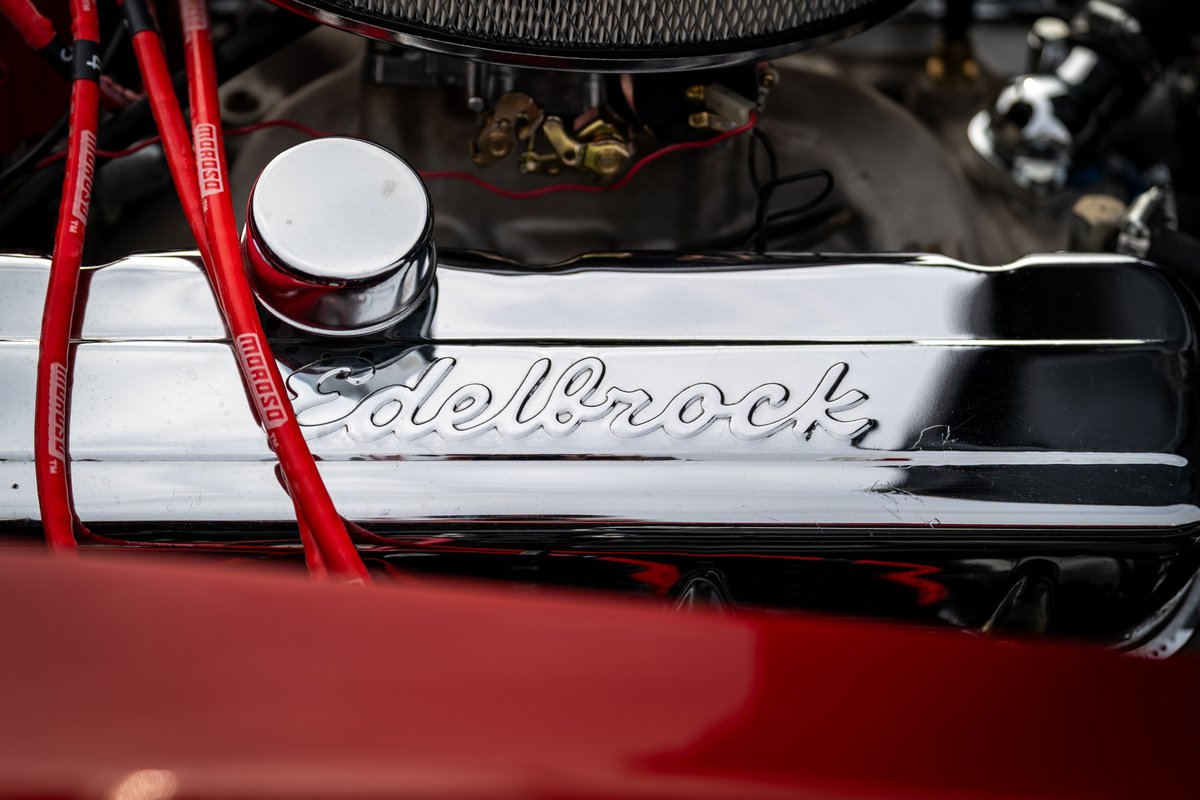 Chrome Edelbrock valve cover on a red 1965 Corvette hot rod engine.