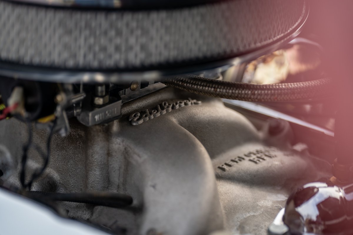 Closeup of a polished aluminum Edelbrock intake manifold on a 1965 Chevrolet Corvette.