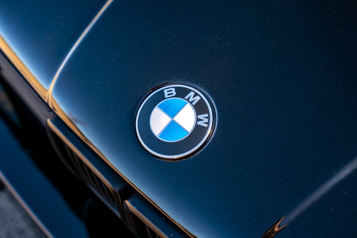 Close up of the BMW emblem on the hood of a black 1989 BMW 325is.