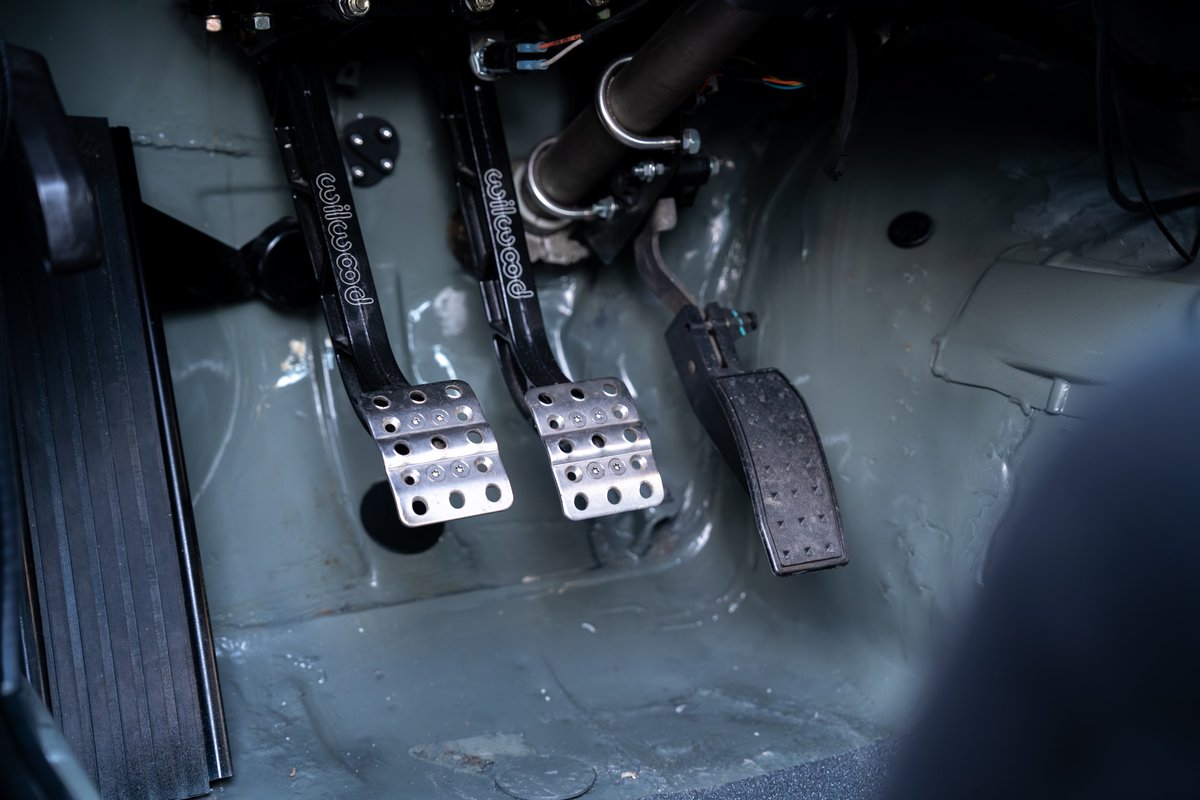 Custom Wilwood brake and clutch pedals in a black 1989 BMW 325is.