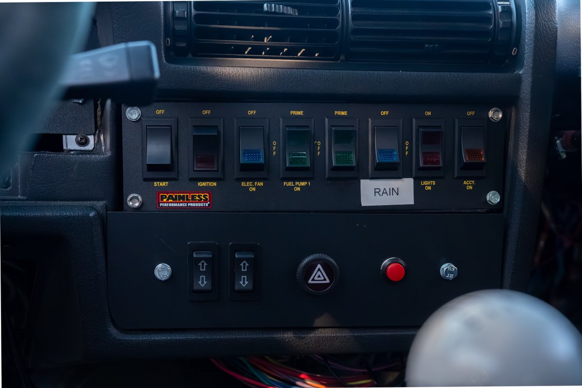 Customized dashboard with Painless Performance Products switch panel in a black 1989 BMW 325is.