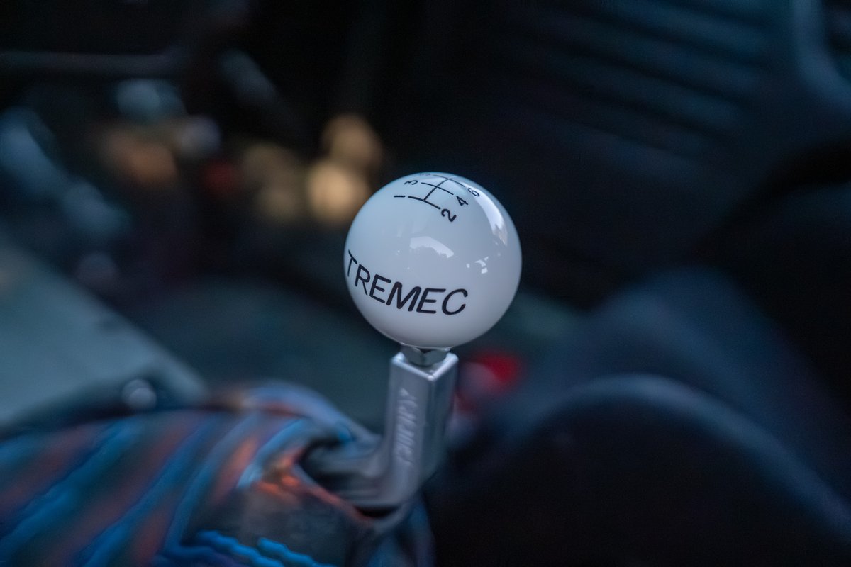 Close-up of a white TREMEC 6-speed manual shifter in a black 1989 BMW 325is.