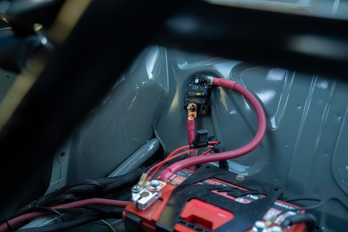 1989 BMW 325is LS1 battery and circuit breaker setup, black interior trim.