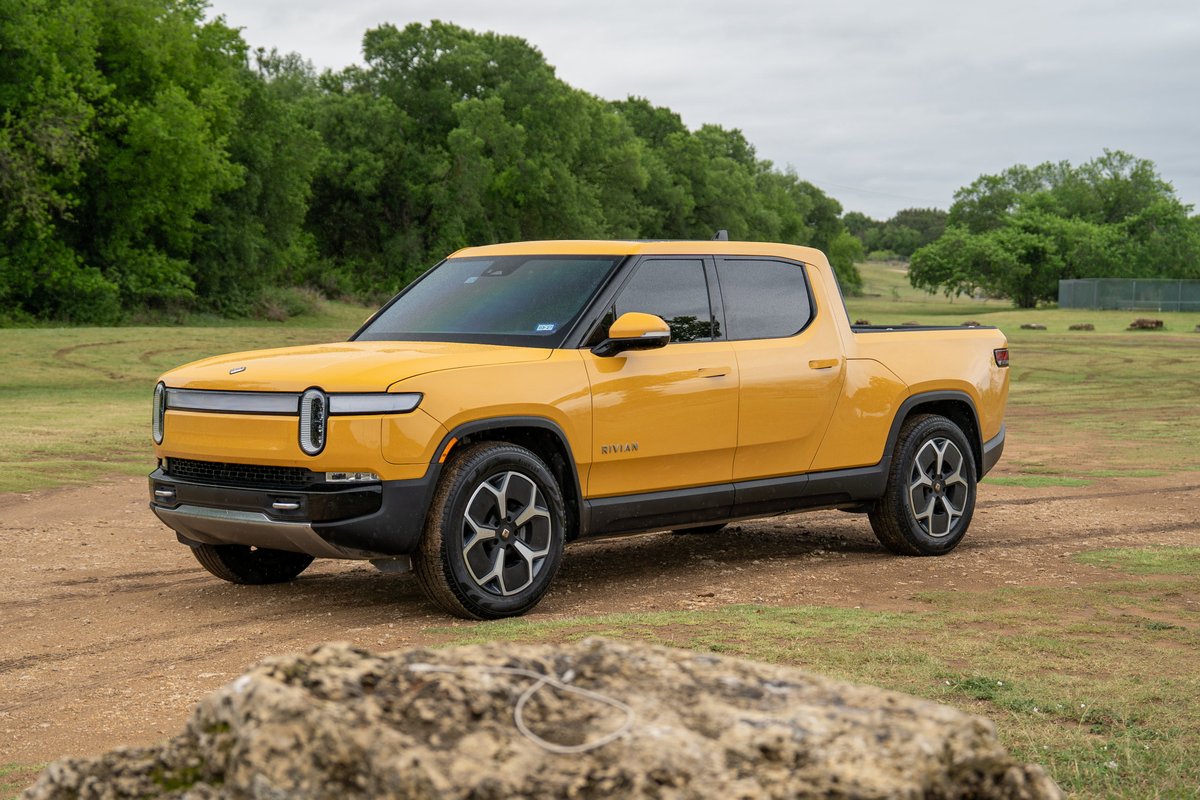 Yellow 2022 Rivian R1T electric pickup truck with alloy rims and black trim.