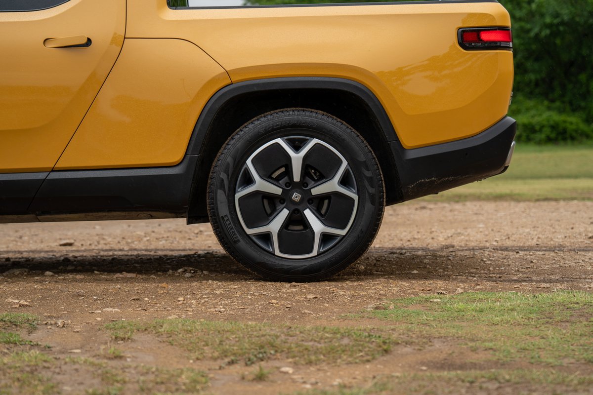 Yellow Rivian R1T pickup truck with black trim and unique alloy rims.