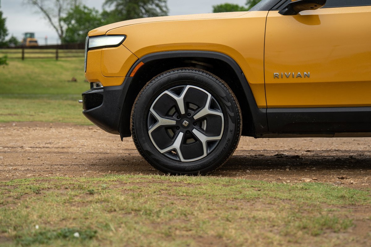 Yellow Rivian R1T with black trim and unique wheel rims.