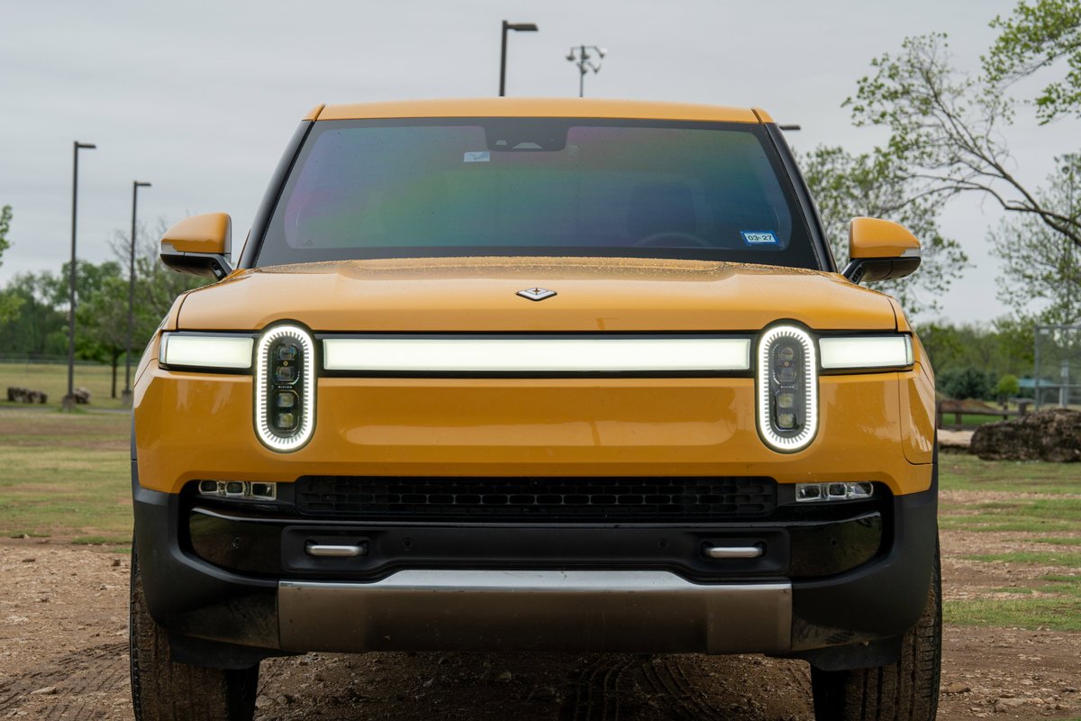 Front view of a yellow 2022 Rivian R1T electric pickup truck with unique oval LED headlights.