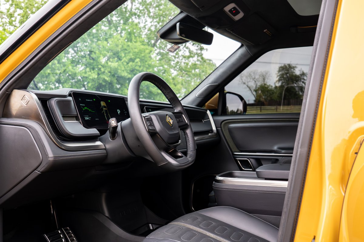Yellow Rivian R1T interior with digital dashboard and leather seats.