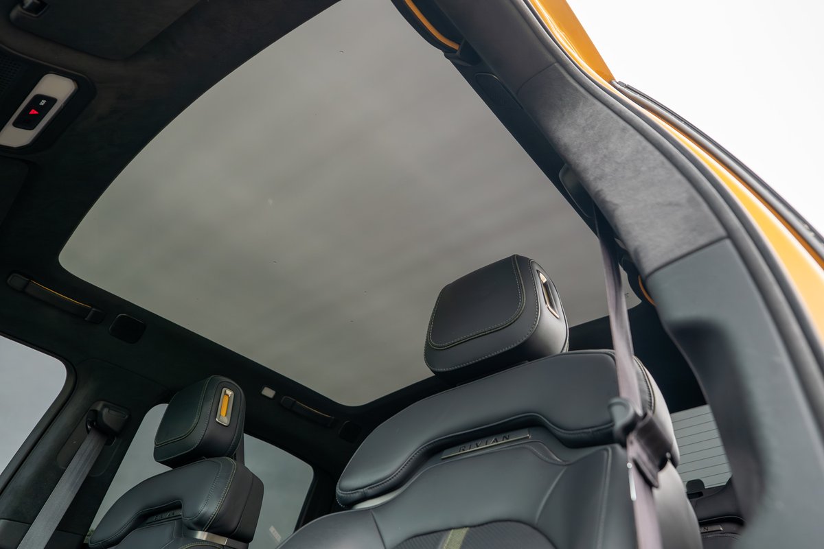 Yellow Rivian R1T interior: Panoramic sunroof, black leather seats, suede headliner.
