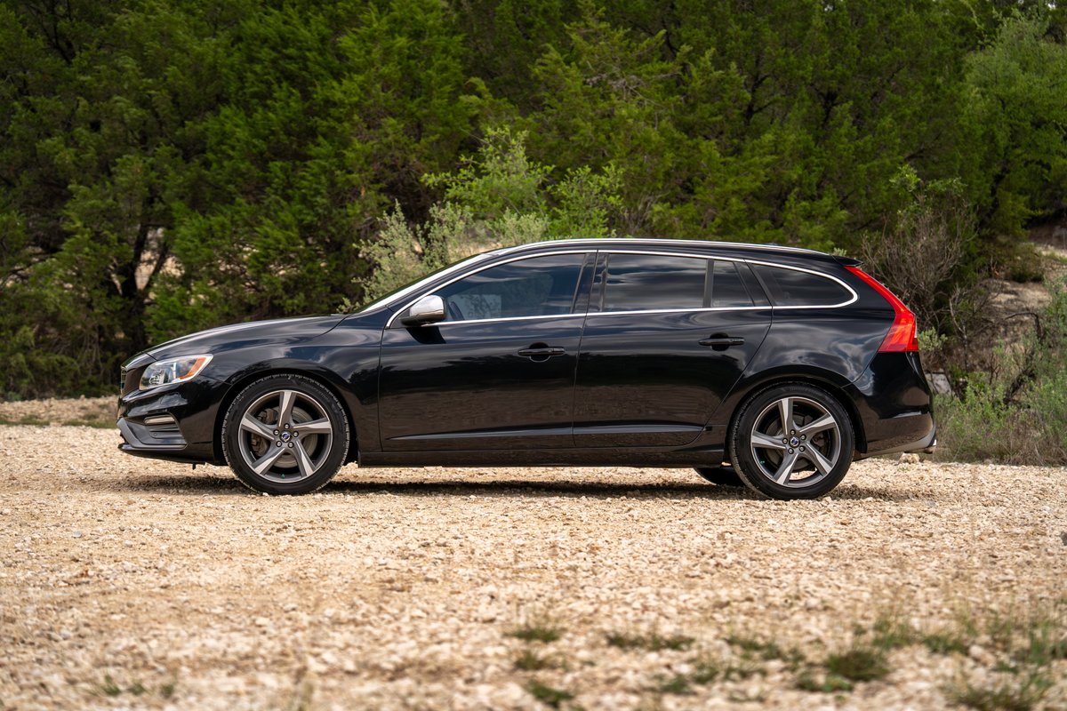 2015 black Volvo V60 R-Design Polestar wagon with silver rims and chrome trim.