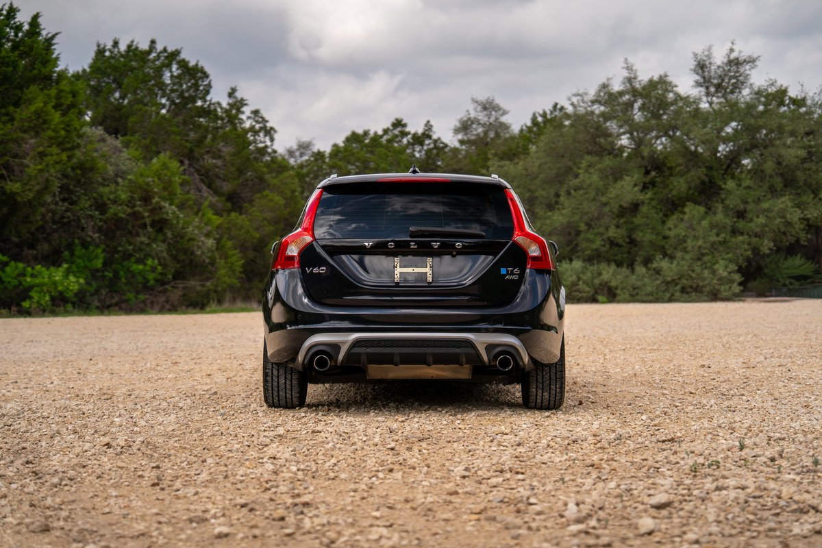 Rear view of a black 2015 Volvo V60 R-Design Polestar with dual exhaust and distinctive red trim.
